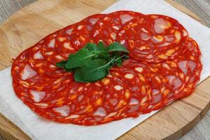 Chorizo sausage on wooden board and wooden background photo