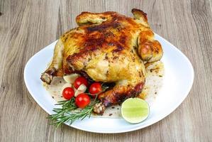 Grilled chicken on the plate and wooden background photo