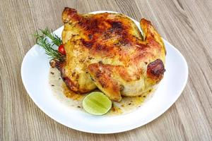 Grilled chicken on the plate and wooden background photo