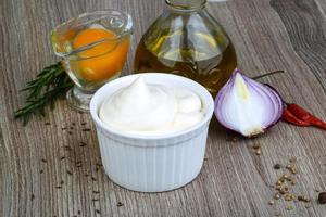 Mayonnaise sauce in a bowl on wooden background photo