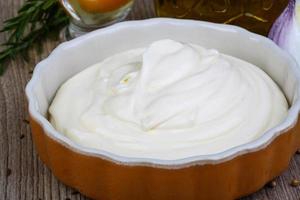 Mayonnaise sauce in a bowl on wooden background photo