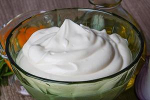 Mayonnaise sauce in a bowl on wooden background photo