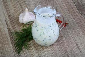 Tzatziki on wooden background photo