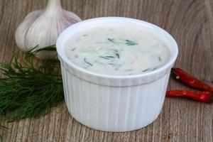 Tzatziki in a bowl on wooden background photo