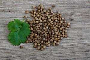 semillas de cilantro sobre fondo de madera foto