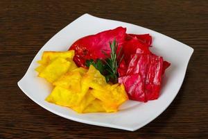 Pickled cabbage on the plate and wooden background photo