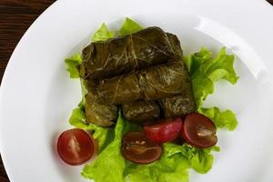 Dolma on the plate and wooden background photo