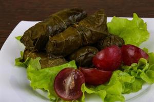 dolma en el plato y fondo de madera foto