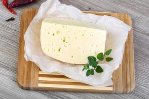 Cheese on wooden board and wooden background photo