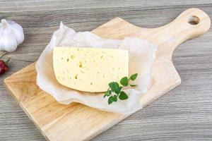 Cheese on wooden board and wooden background photo