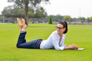 Beautiful young woman with  tablet in park photo