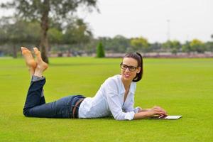 Beautiful young woman with  tablet in park photo