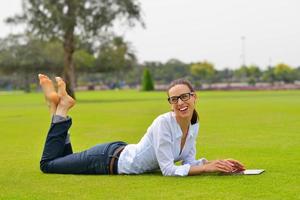 hermosa mujer joven con tableta en el parque foto