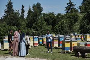 grupo de personas que visitan la granja local de producción de miel foto
