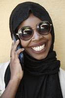 african  woman using smartphone wearing traditional islamic clothes photo