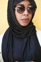 african  woman using smartphone wearing traditional islamic clothes photo