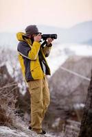 fotógrafo masculino tomando fotografías del bosque de invierno foto