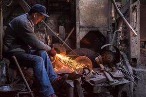 the blacksmith polishing metal products photo