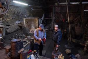 portrait of two generations traditional blacksmith photo