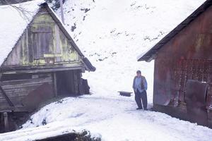 traditional senior blacksmith in front of watermill photo