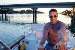 portrait of happy young man on boat photo