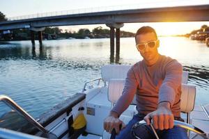 portrait of happy young man on boat photo