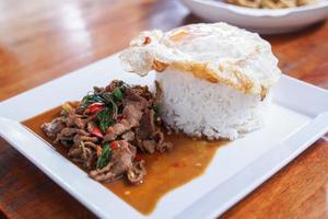 Stir fried beef with basil with fried egg on white plate It's a simple a la carte. that Thai people are very popular. photo