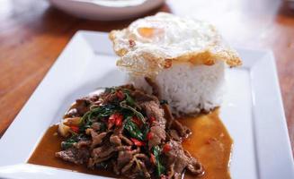 Stir fried beef with basil with fried egg on white plate It's a simple a la carte. that Thai people are very popular. photo