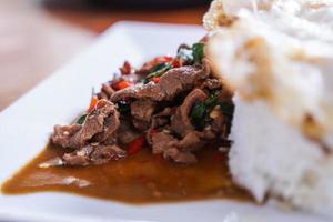 Stir fried beef with basil with fried egg on white plate It's a simple a la carte. that Thai people are very popular. photo