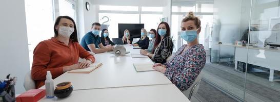 real business people on meeting wearing protective mask photo