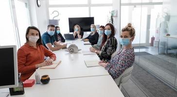 real business people on meeting wearing protective mask photo