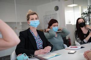 real business people on meeting wearing protective mask photo