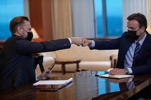 business people wearing  face mask on meeting and handshake photo