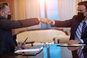 business people wearing  face mask on meeting and handshake photo