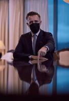 business man wearing protective face mask at luxury office photo