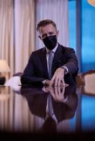 business man wearing protective face mask at luxury office photo