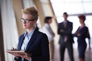 business woman  at office with tablet  in front  as team leader photo