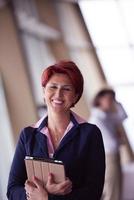 business woman  at office with tablet  in front  as team leader photo