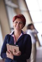 business woman  at office with tablet  in front  as team leader photo