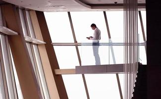 young successful business man in penthouse apartment working on tbalet photo