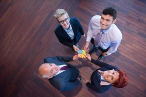 top view of business people group assembling jigsaw puzzle photo