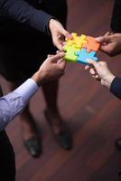 top view of business people group assembling jigsaw puzzle photo