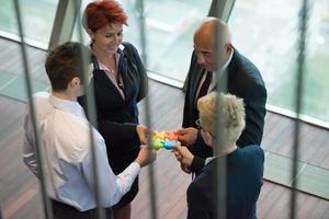 top view of business people group assembling jigsaw puzzle photo