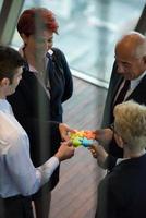 top view of business people group assembling jigsaw puzzle photo