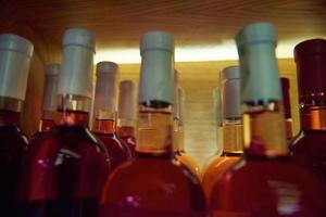 Wine bottles on a wooden shelf. photo