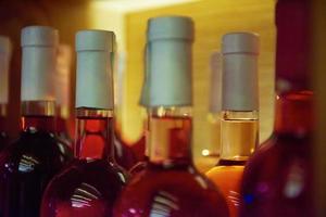 Wine bottles on a wooden shelf. photo