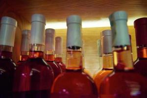 Wine bottles on a wooden shelf. photo