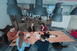 Top view of young multi-ethnic business people working and communicating together in creative office. Selective focus photo