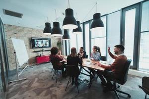 Successful team. Group of young multi-ethnic business people working and communicating together in creative office. Selective focus photo