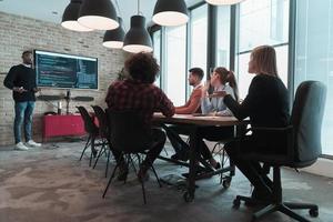 Leader give a business presentation at an office conference meeting, businessman coach mentor explains graph chart on board corporate group workshop training in boardroom. Selective focus photo